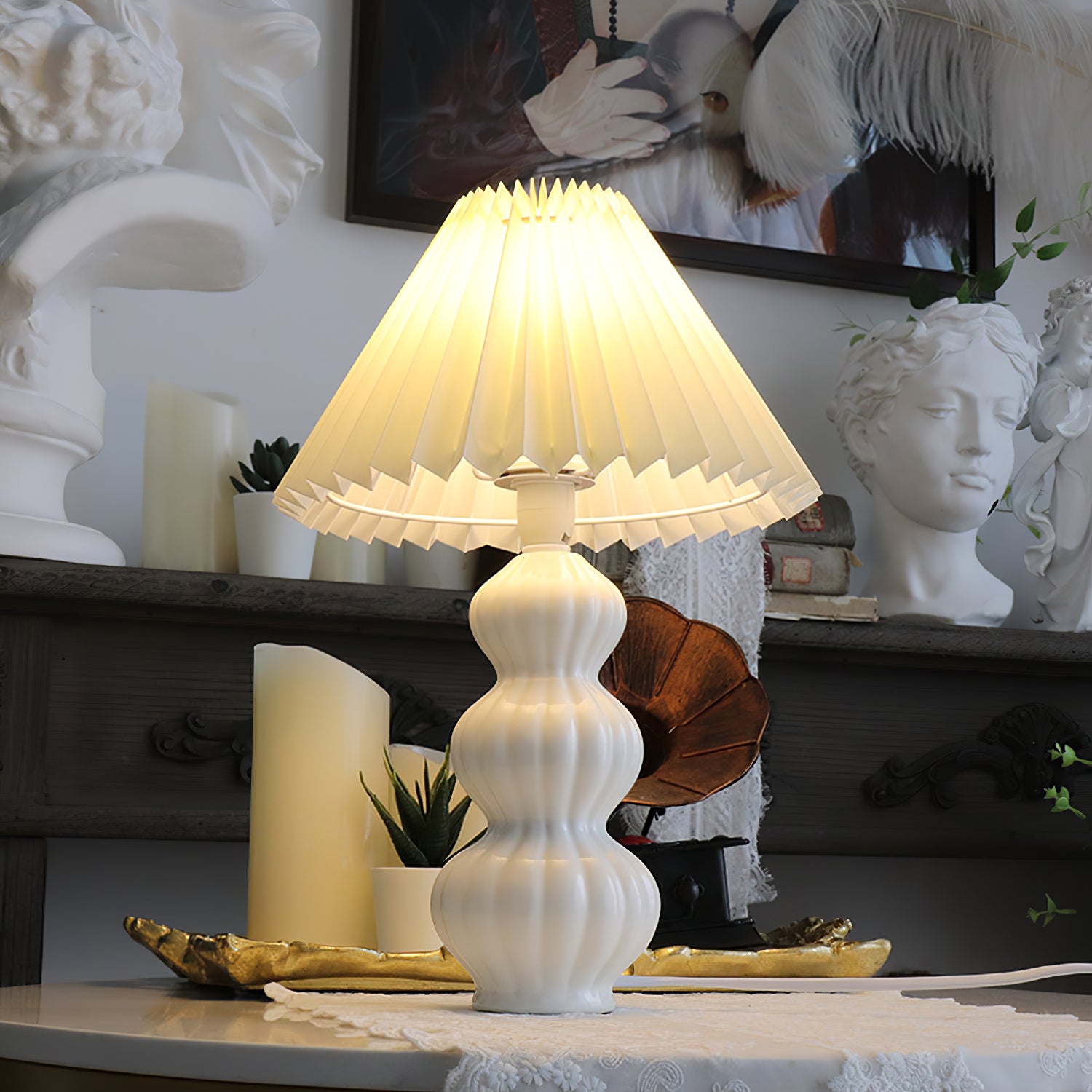 Illuminated Luna pleated table lamp on vintage home shelf, warm beige shade with soft diffused light, mid-century modern aesthetic