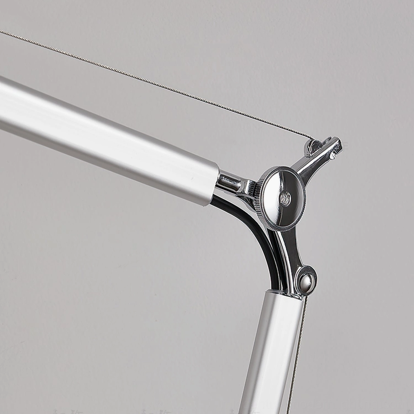 Precision pivot joint mechanism of modern adjustable table lamp, showing tension control and metal engineering detail