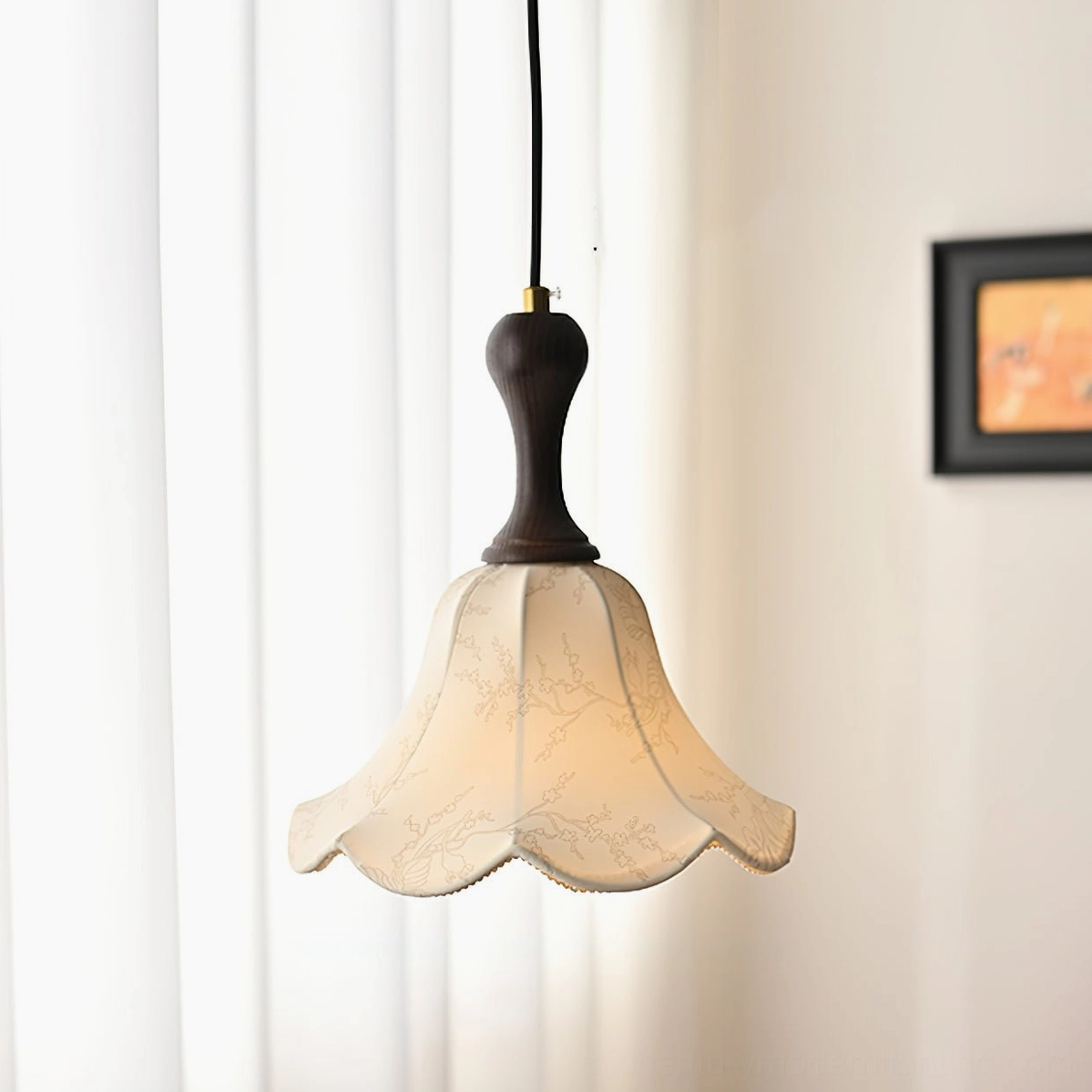 Agnes pendant light hanging indoors with warm glow, side angle view near window curtain