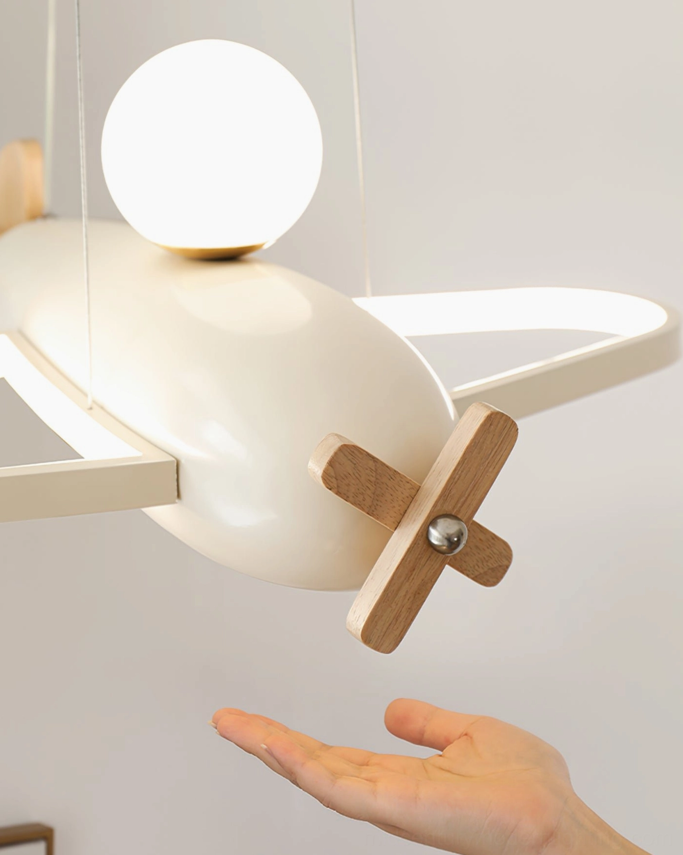 Aircraft pendant lamp close-up detail with wooden propeller and globe bulb