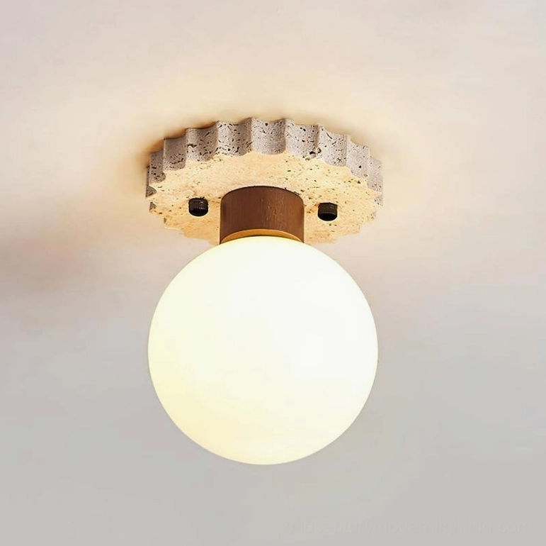 Lit spherical ceiling lamp installed on indoor ceiling emitting warm white ambient light, bottom front view