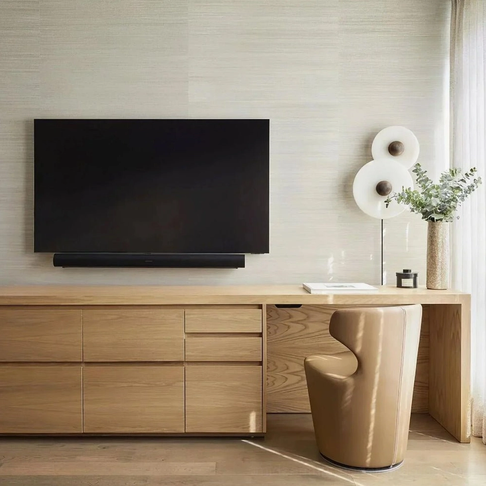 Three-disc alabaster lamp mounted above minimalist TV lounge setup with light wood furniture