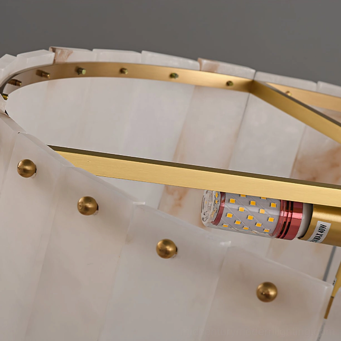 Interior brass metal frame structure of alabaster ceiling light with E14 bulb sockets visible