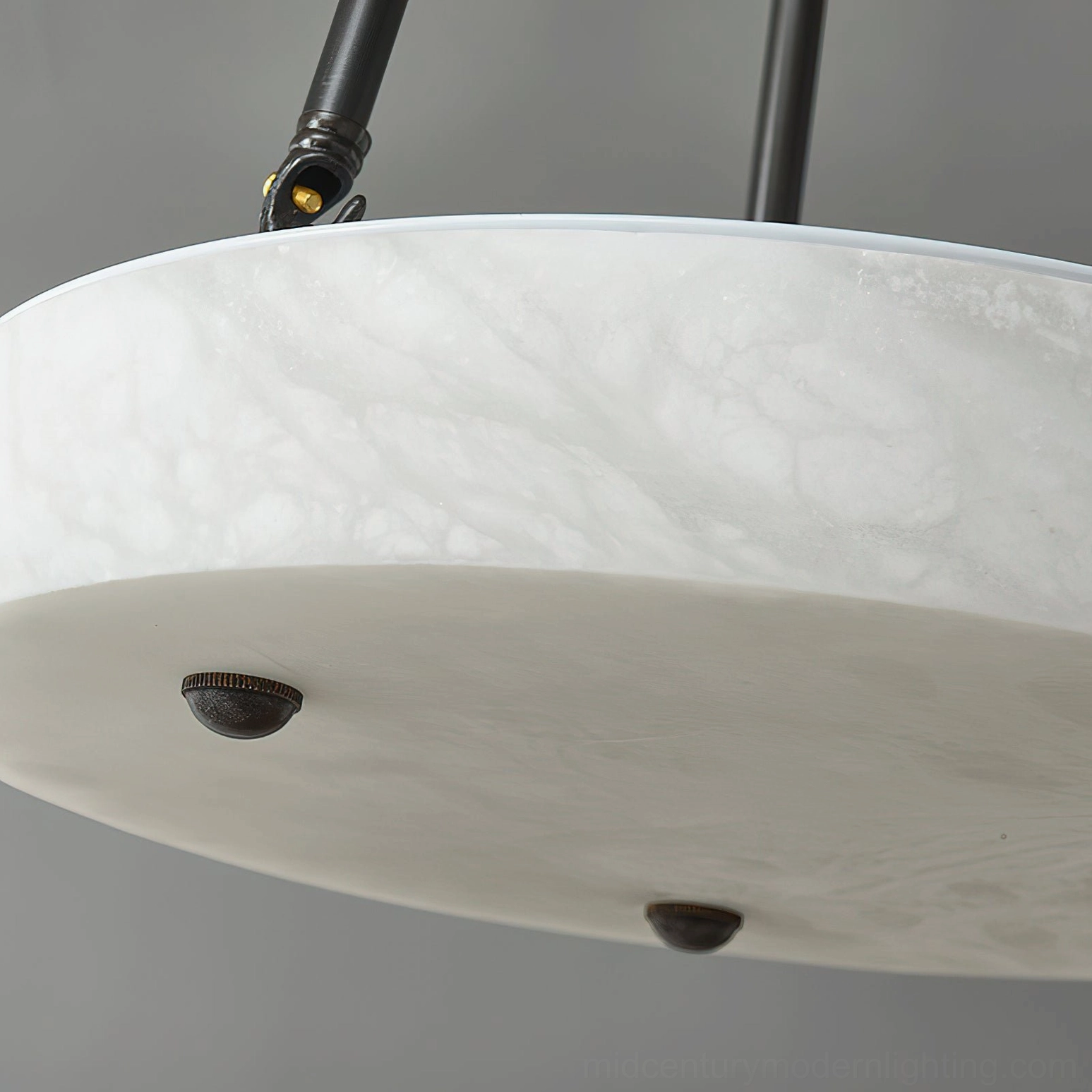 Alabaster lampshade bottom view with smooth stone surface and decorative brass caps