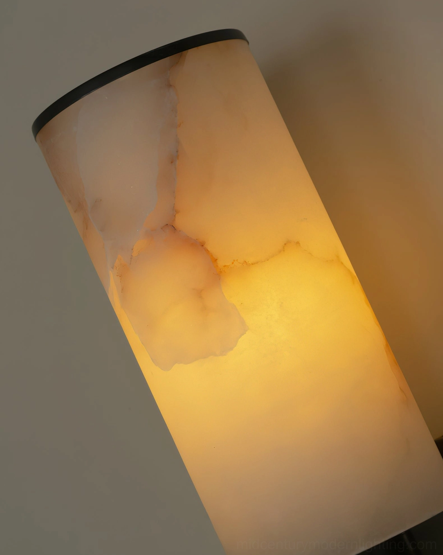 Alabaster cylinder wall sconce natural stone material detail, showing translucent warm glow properties of stone shade