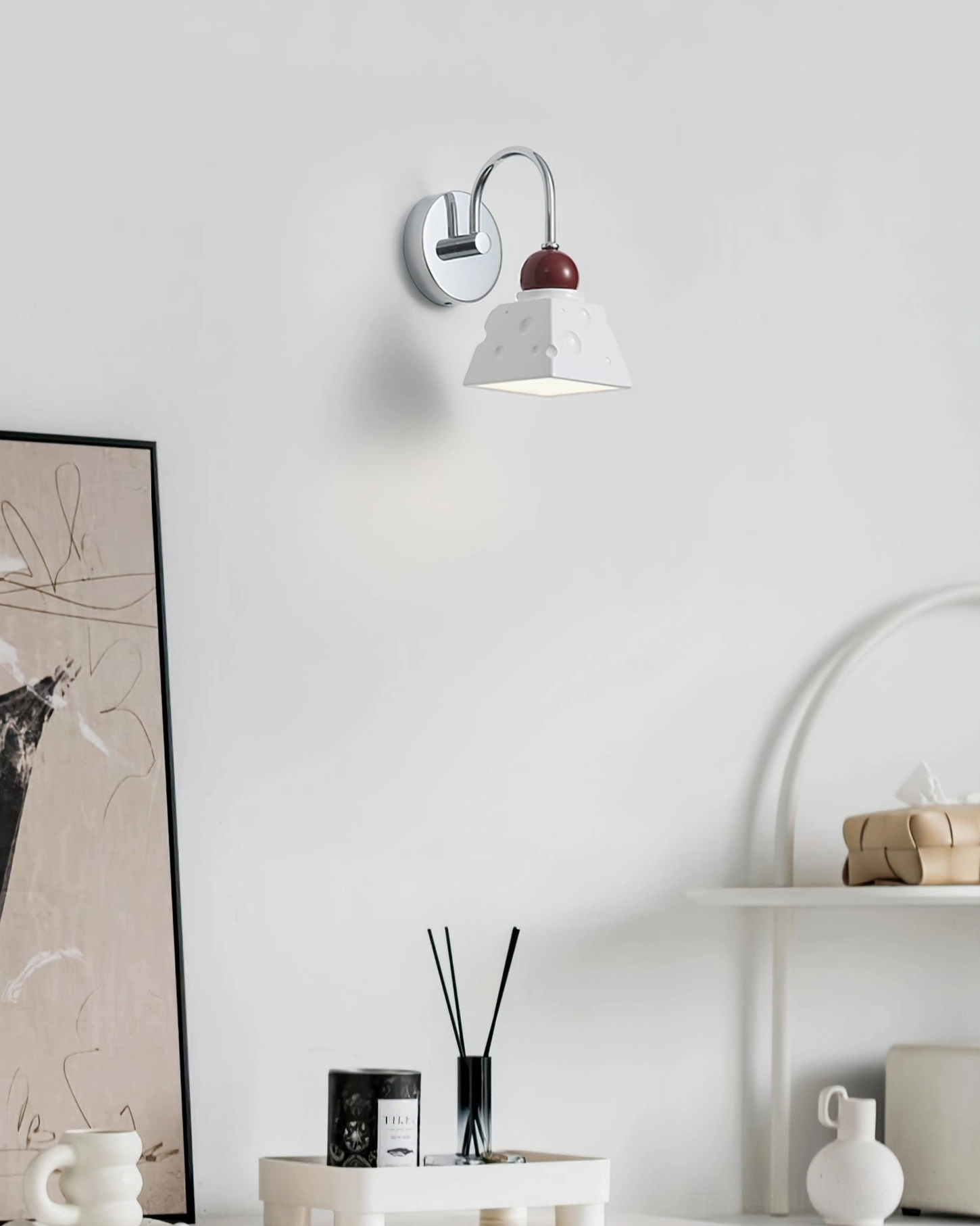Alma cream wall sconce in minimalist entryway, styled with wall art and home accessories