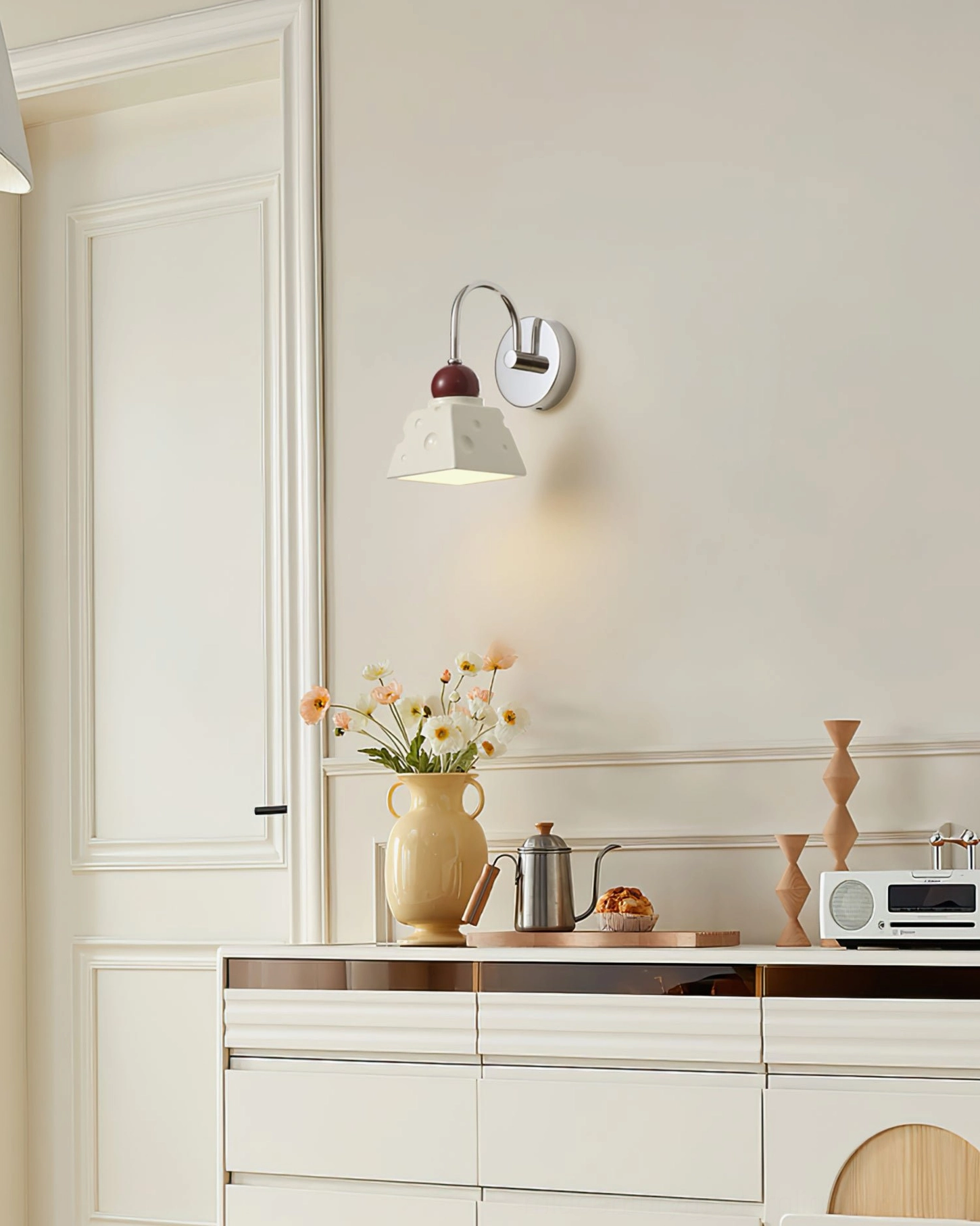 Alma contemporary wall light in dining area with floral centerpiece and home decor styling