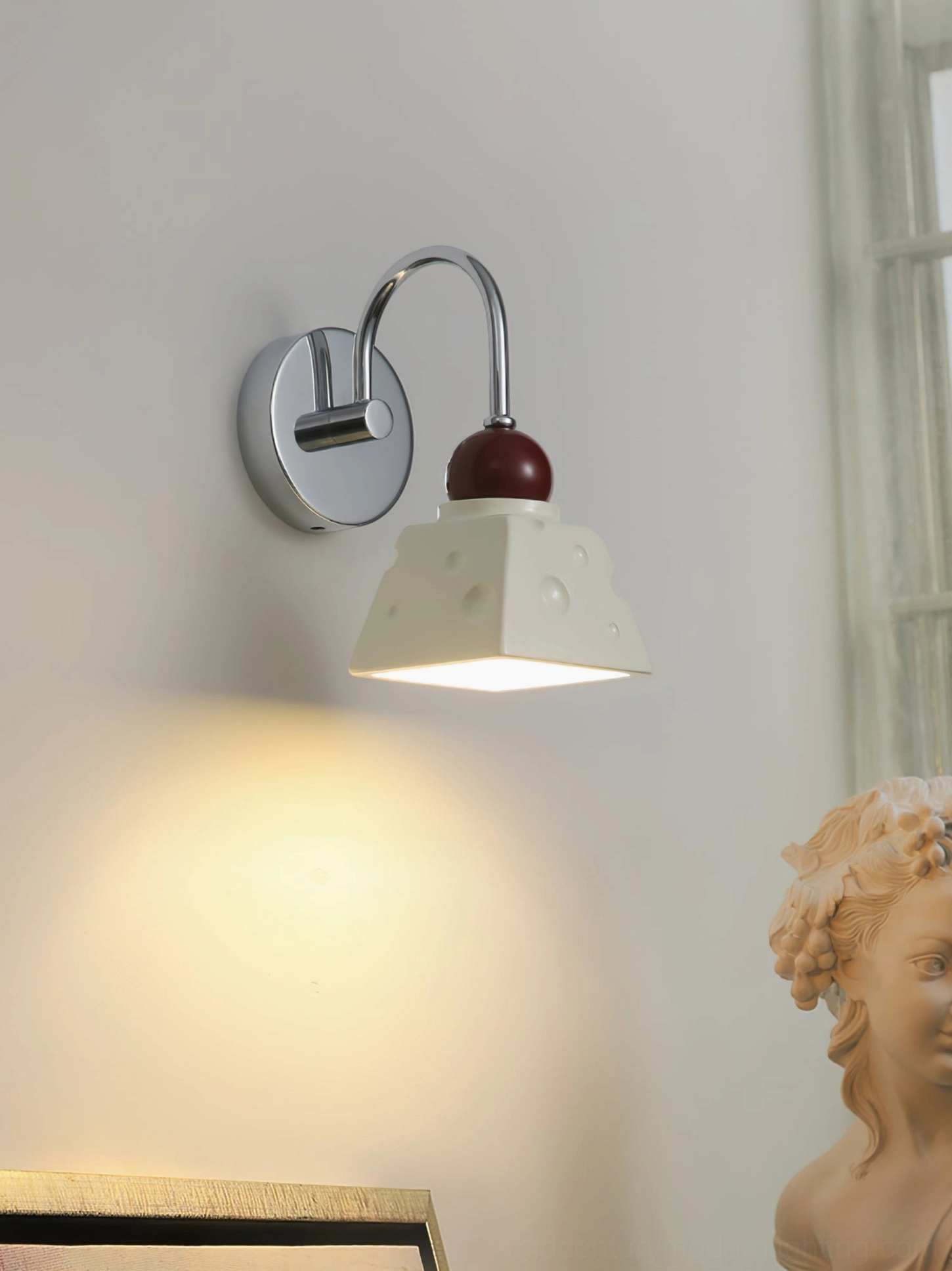 Alma sculptural wall sconce in living room corner with art sculpture and accent lighting