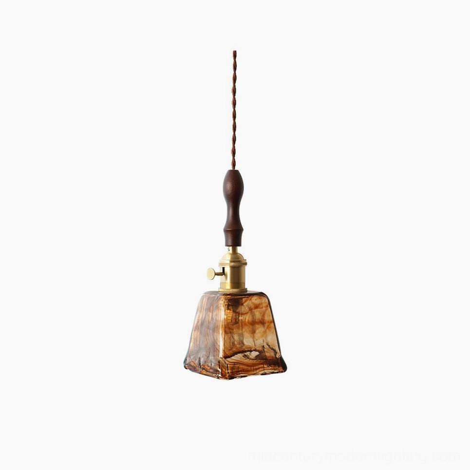 Amber glass pendant lamp with sculptural form and brass hardware, front-facing studio view