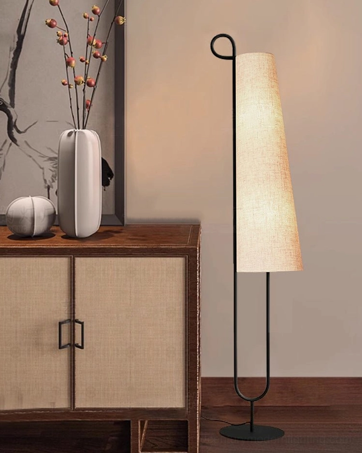 Ancora minimalist floor lamp in entryway with wooden storage cabinet, decorative vase and artwork display