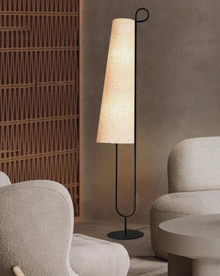 Ancora floor lamp casting soft warm light in modern living room with light grey fabric sofas, three-quarter view