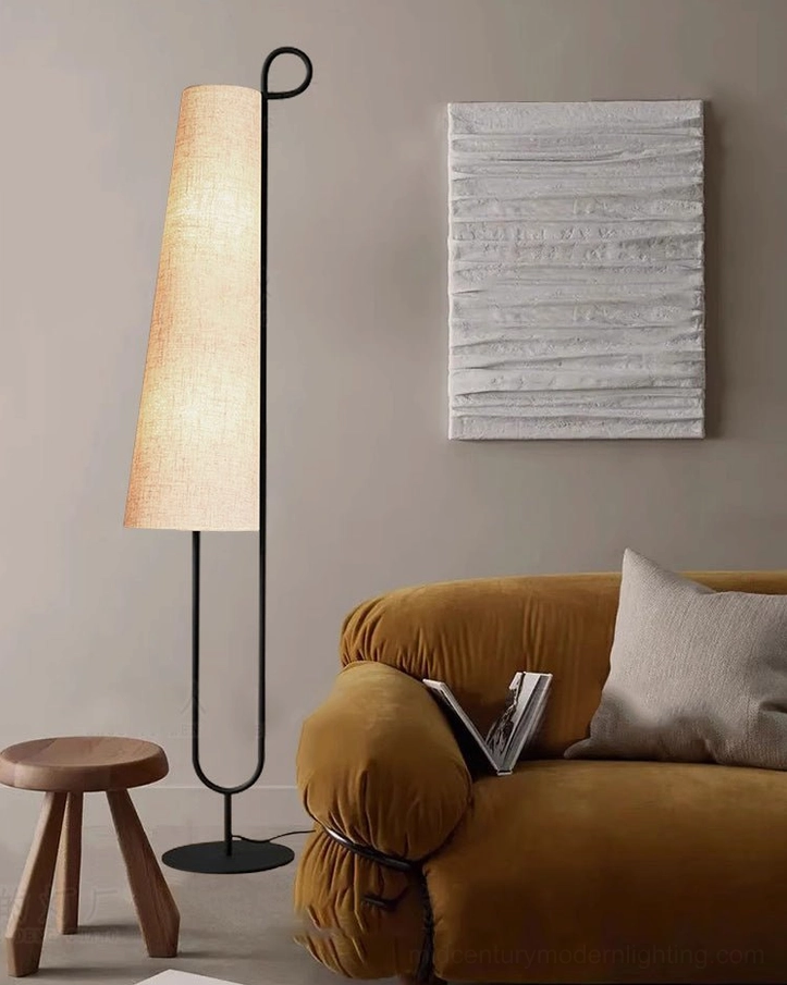 Ancora floor lamp in living room with mustard yellow sofa and wooden stool, mid-century modern aesthetic