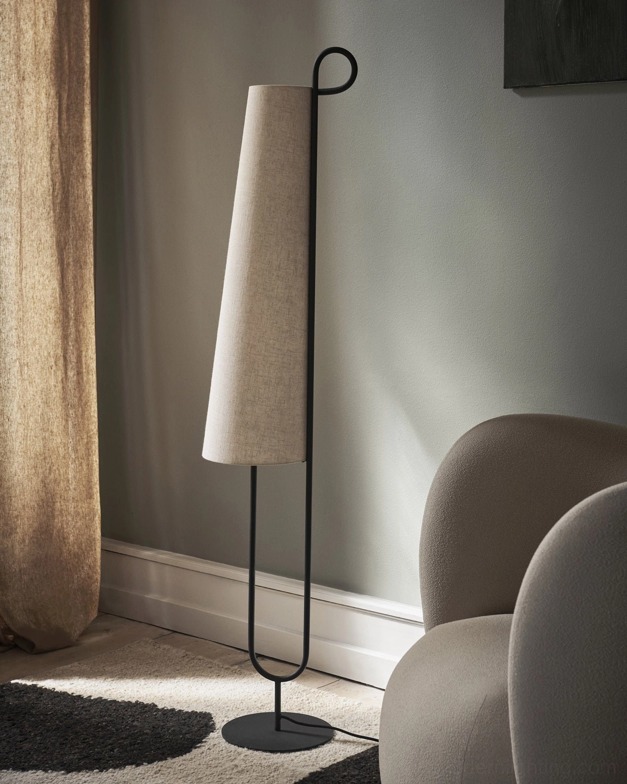 Modern Ancora floor lamp in living room creating warm neutral atmosphere with muted color palette and soft ambient lighting