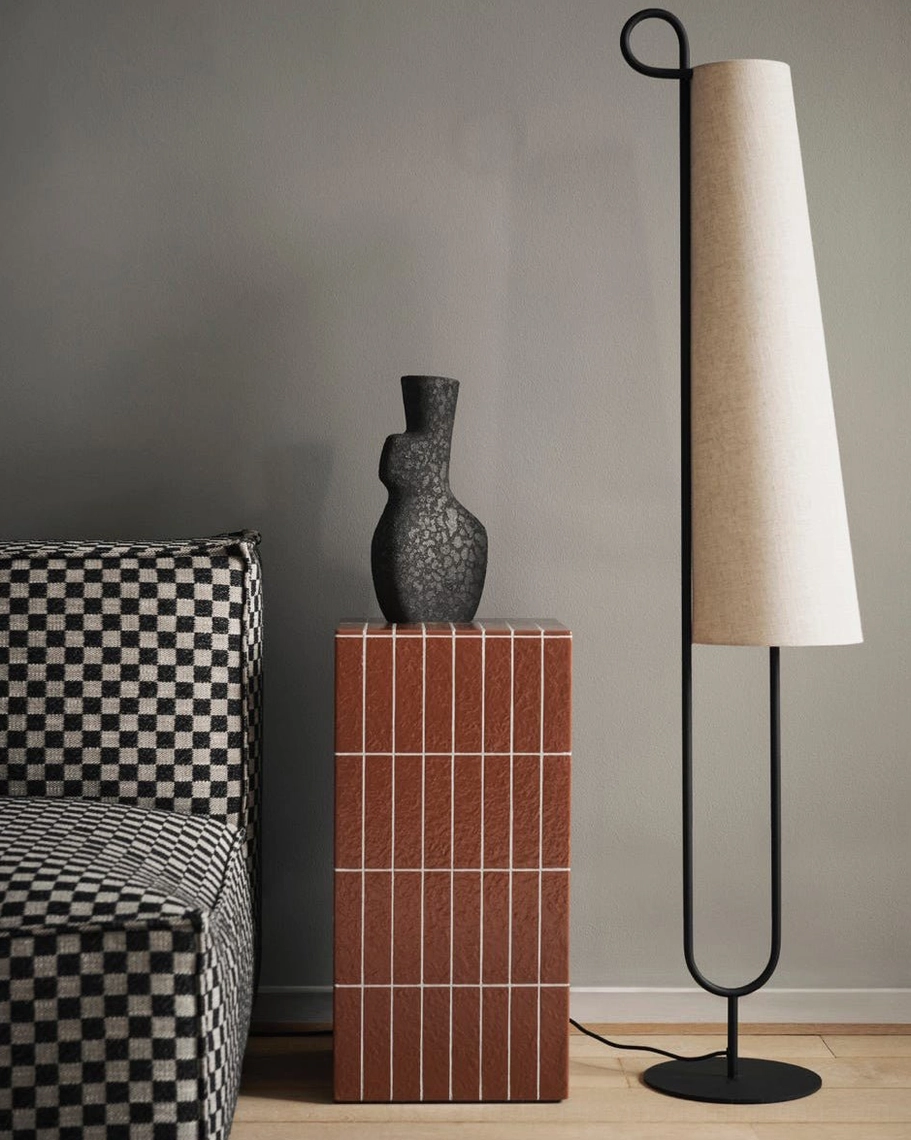 Ancora minimalist floor lamp beside checkered sofa and side table, wabi-sabi interior design style