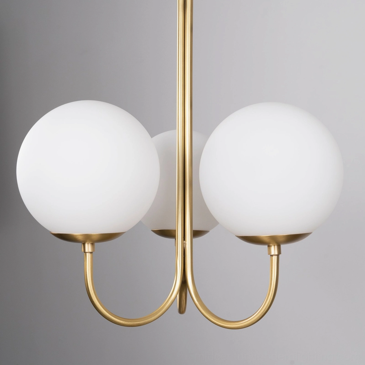 3-head angle chandelier in contemporary space showing warm brass patina and glass light diffusion
