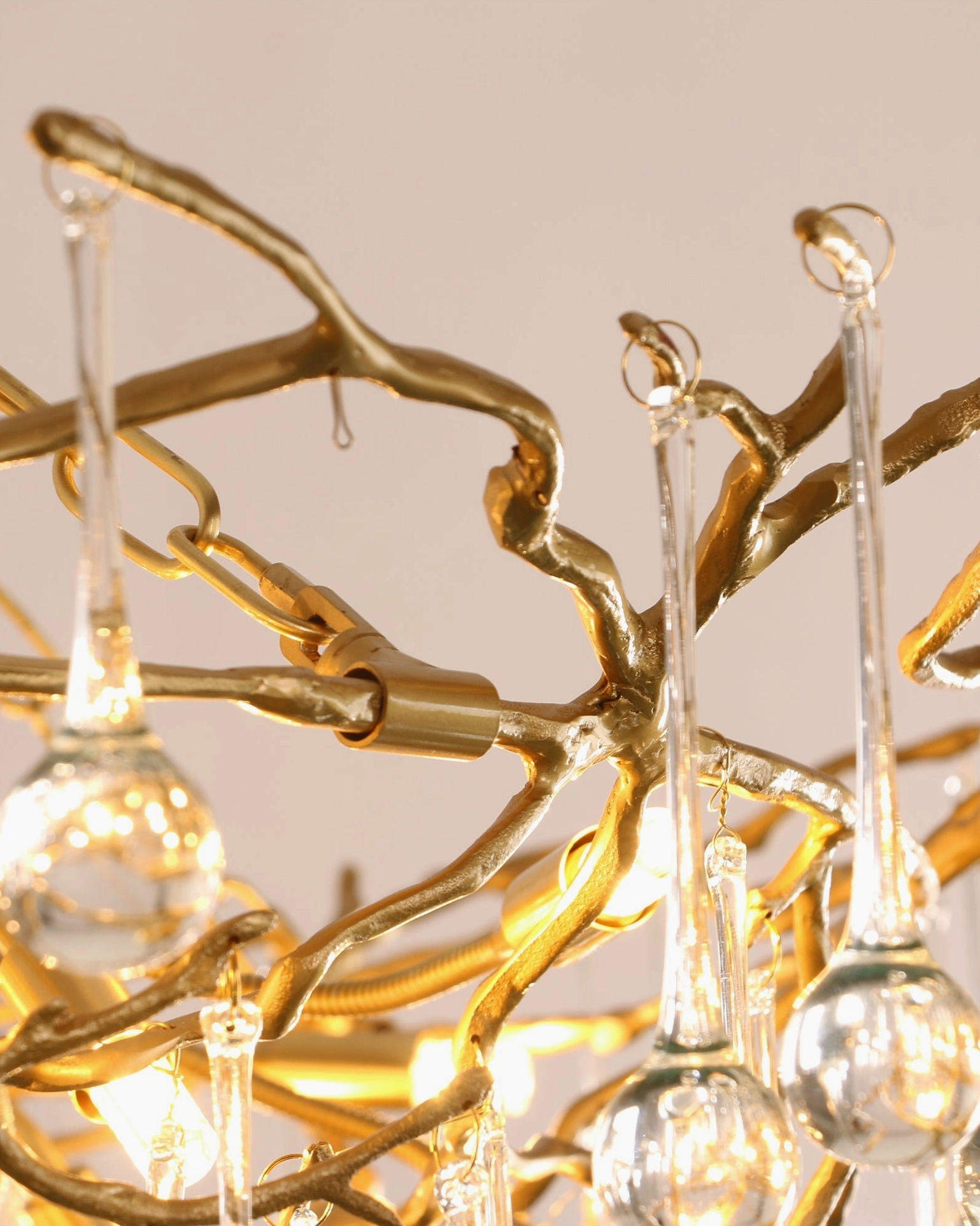 Detailed macro shot of Anita brass chandelier frame with twisted metal texture and crystal mounts
