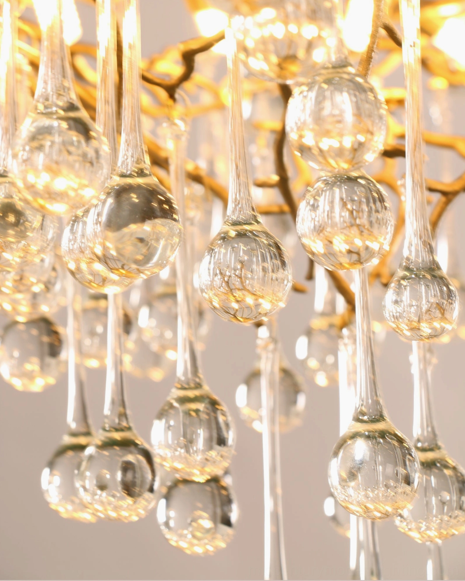 Macro close-up of Anita chandelier crystal teardrops with warm gold lighting and sparkle effect