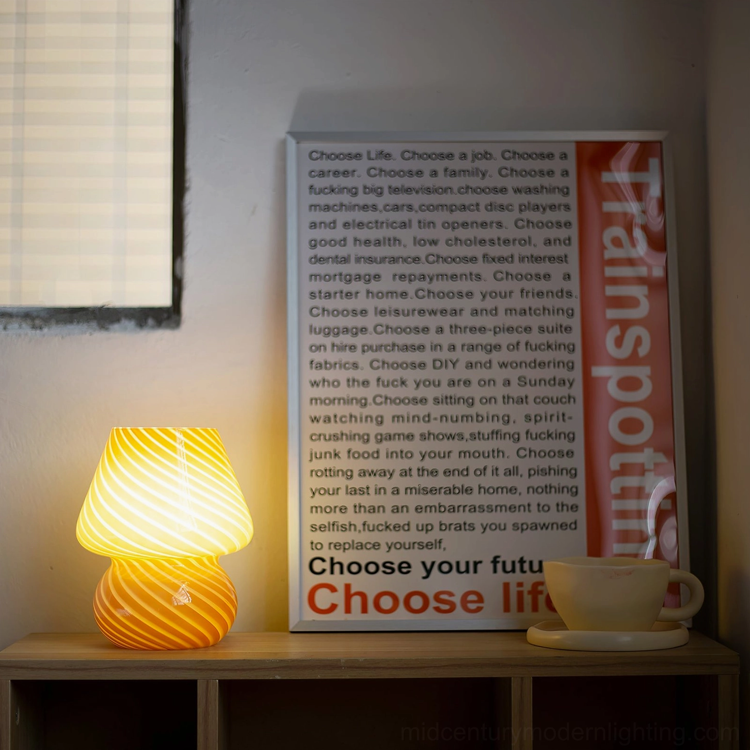 Lit amber Ansel mushroom glass lamp with warm orange glowing light on wooden shelf corner