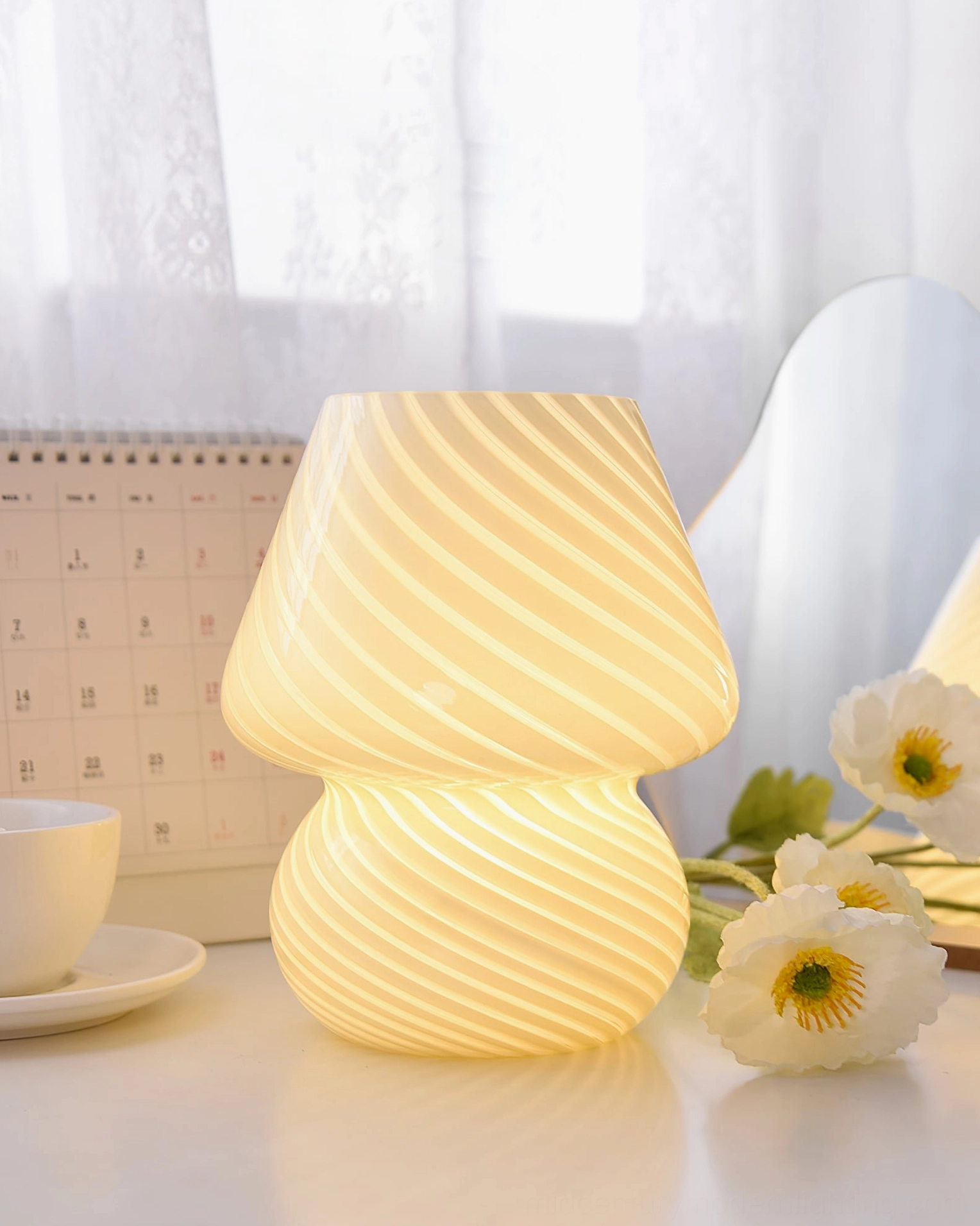 Ansel handcrafted glass table lamp illuminated showing warm light diffusion through patterned surface
