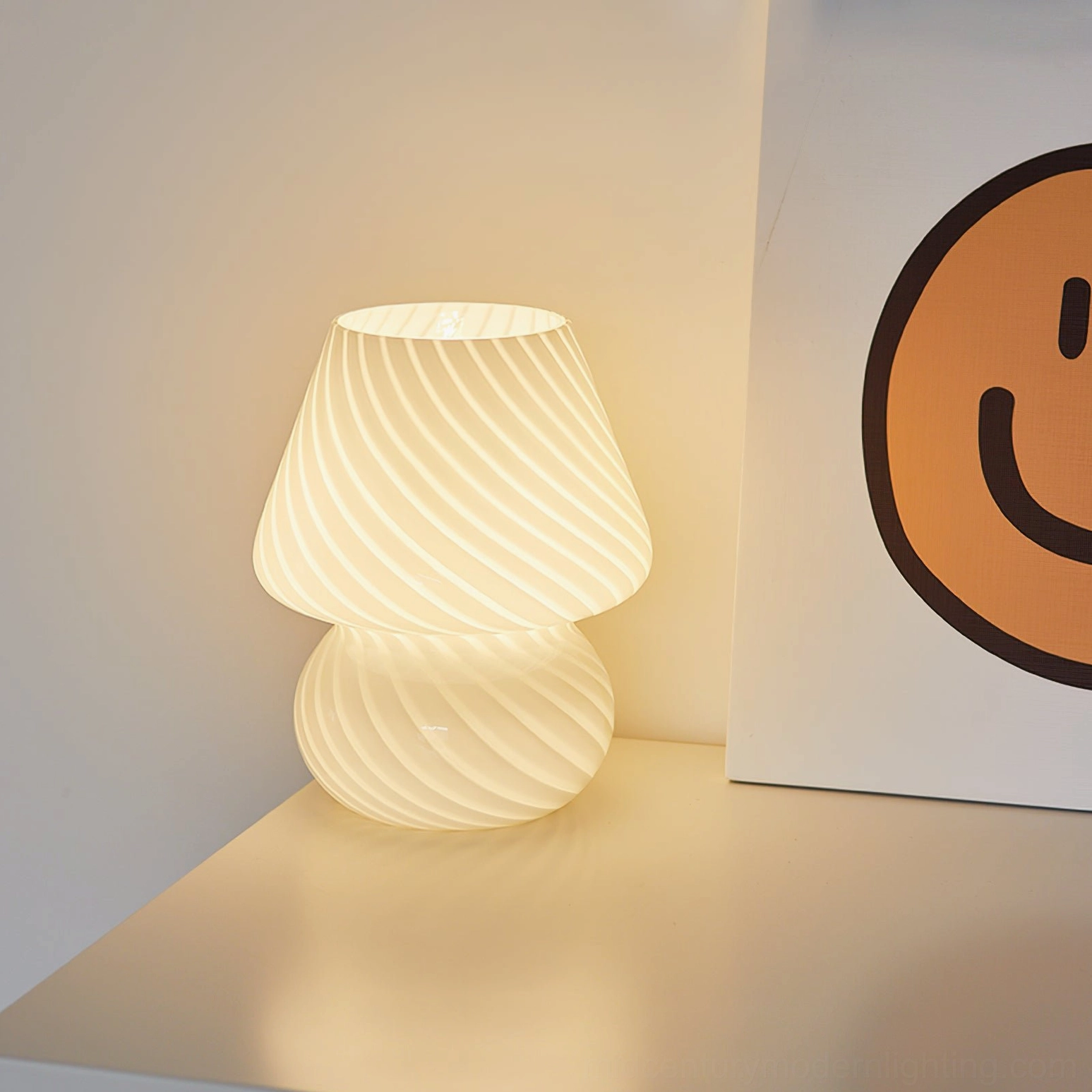 Lit Ansel striped mushroom table lamp with warm glowing light on minimalist wall corner desk setup