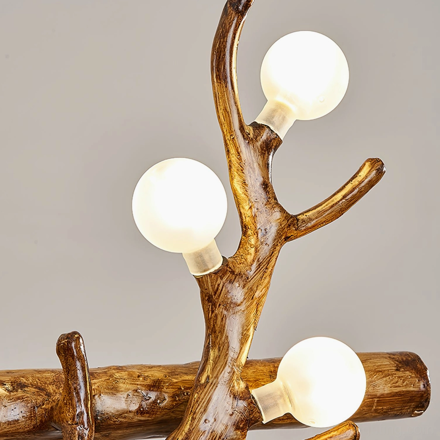 Low-angle macro shot showing multiple exposed round light bulbs on antler branch chandelier structure