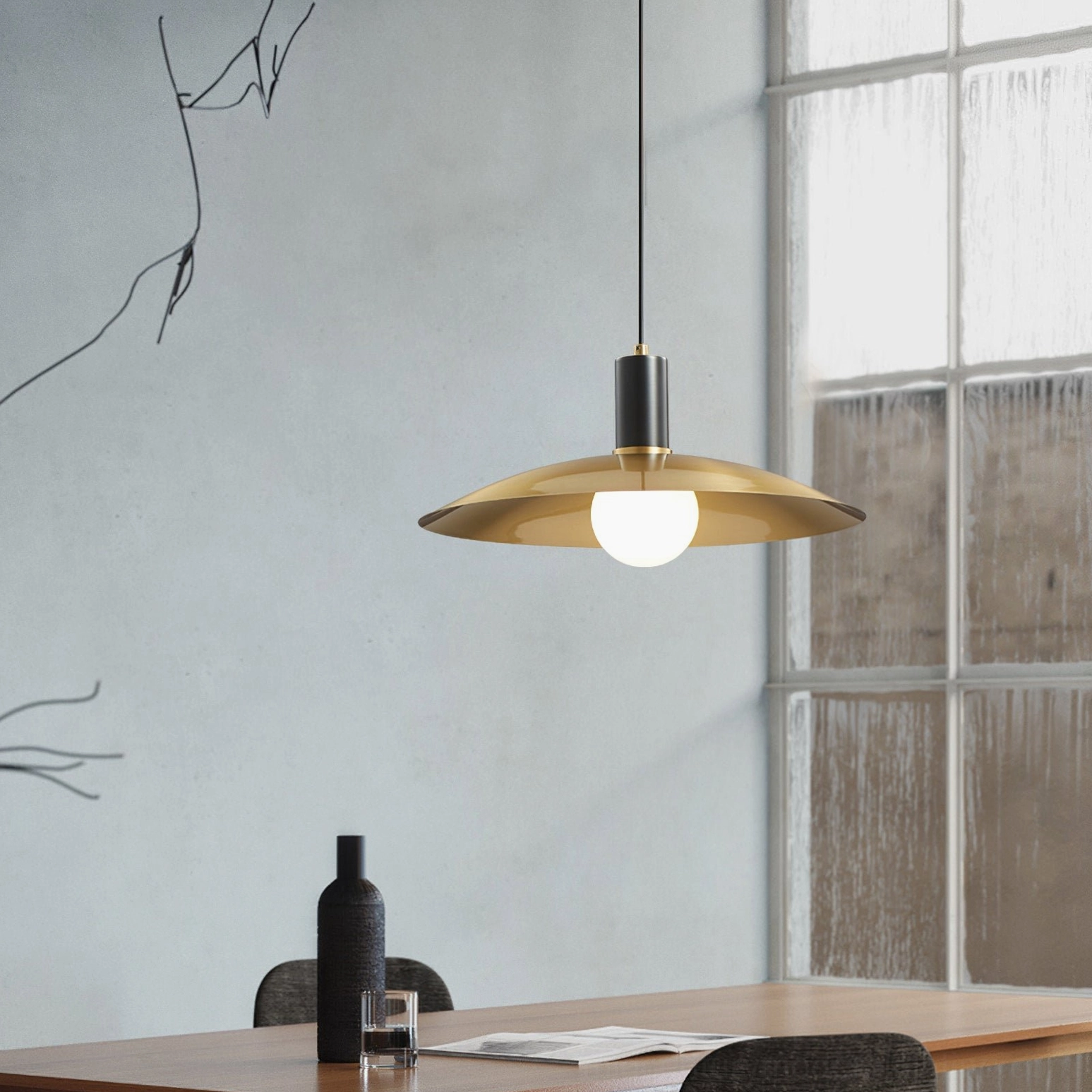 Aplomb brass pendant light in dining nook with large floor window, warm modern lighting