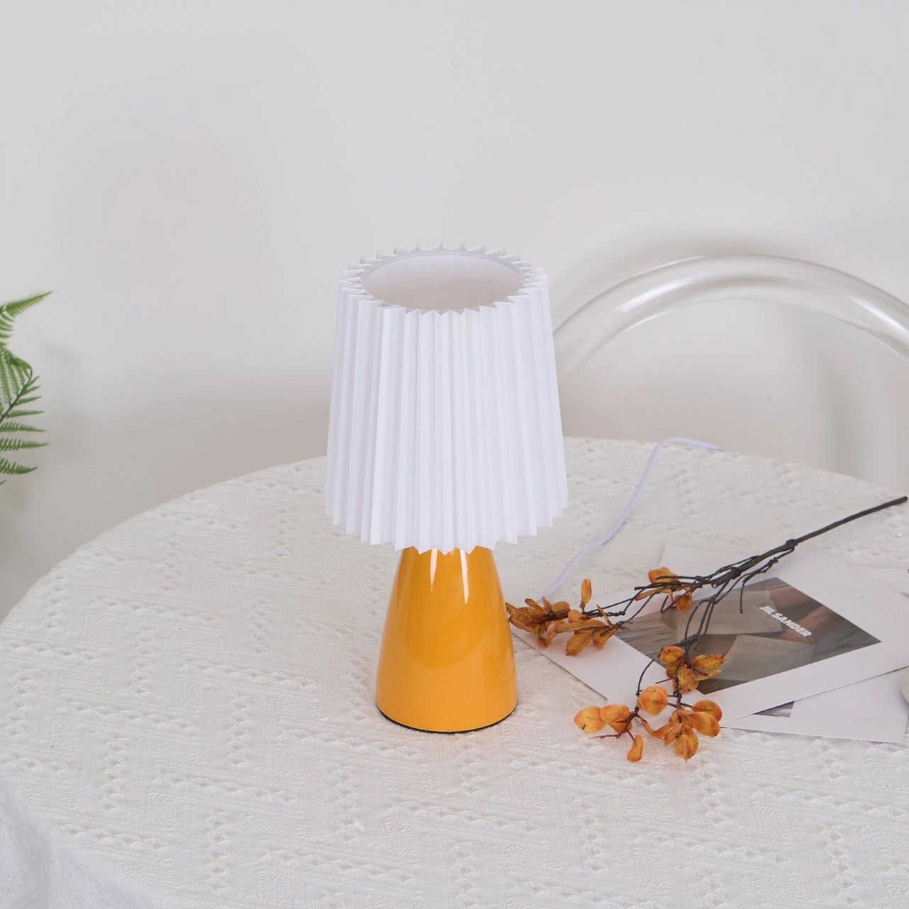 Apollo table lamp with orange ceramic base on dining table, unlit modern minimalist setting