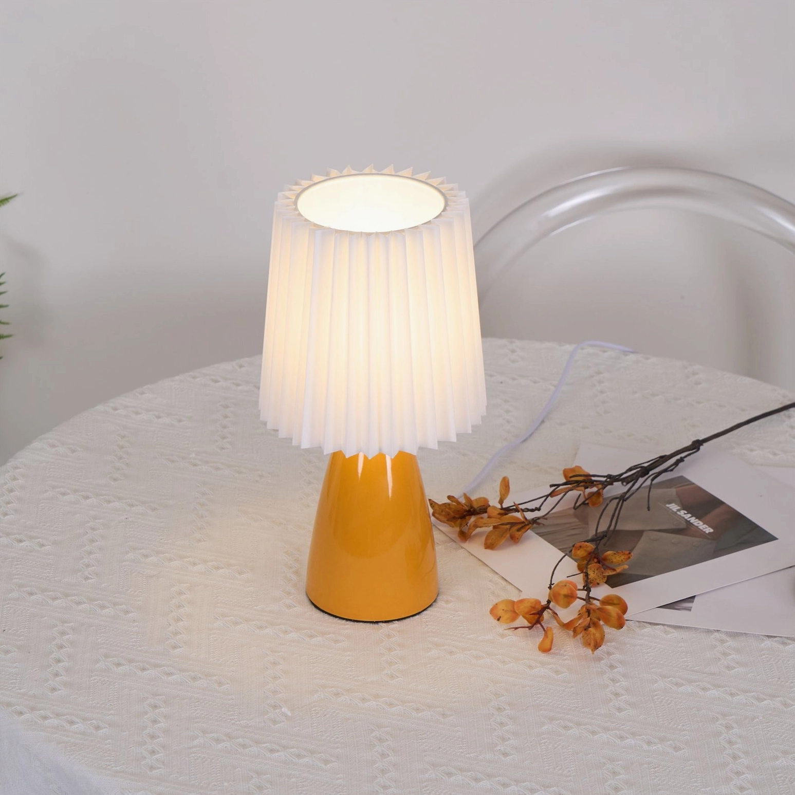 Apollo pleated fabric shade detail on dining table, close-up of pleats and warm light diffusion