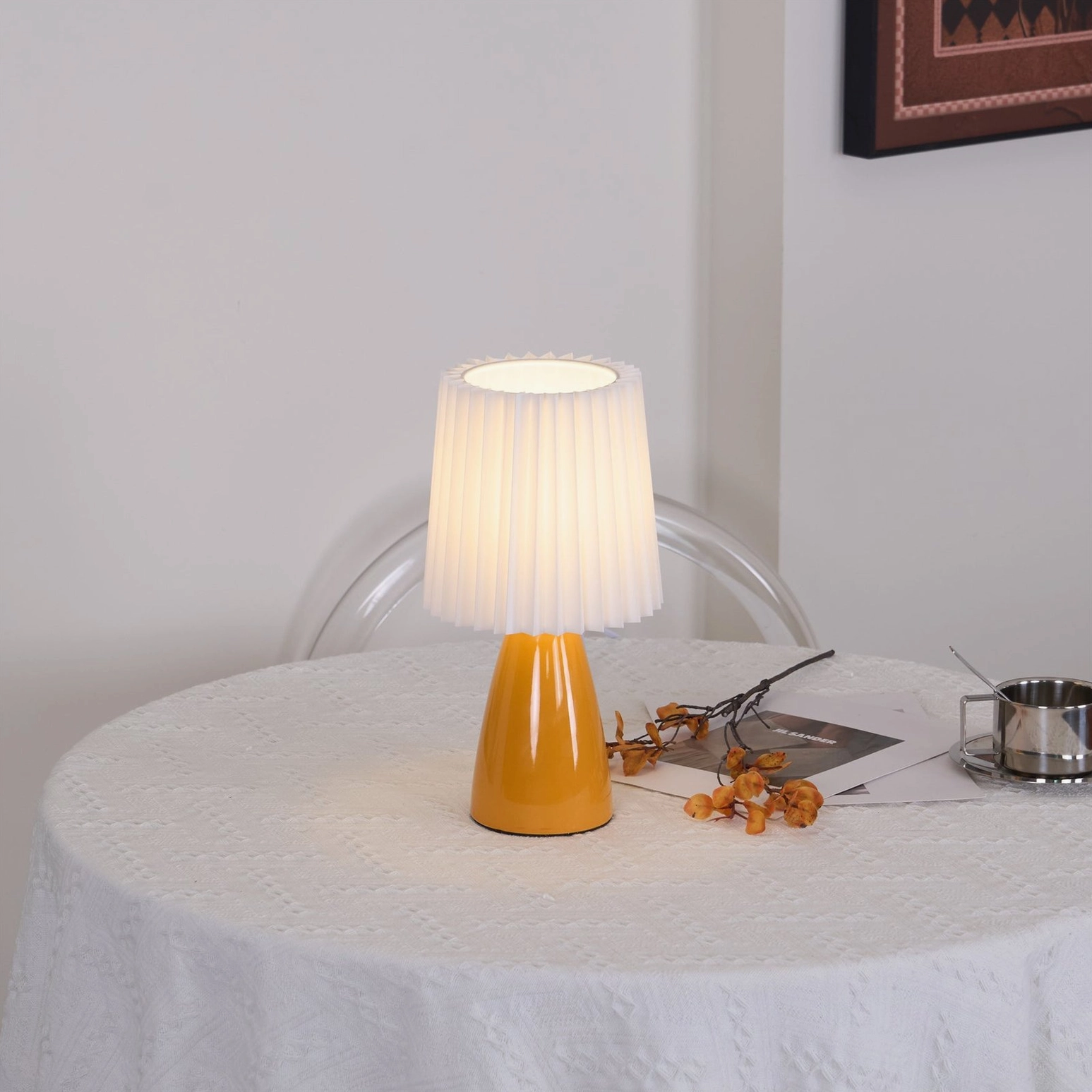 Apollo ceramic table lamp side view with warm glow on dining table, metal cup styling