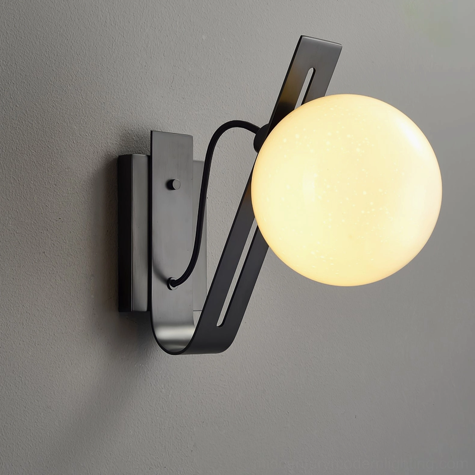 Illuminated black Arandela wall lamp three-quarter view on grey studio wall, mid-century modern style
