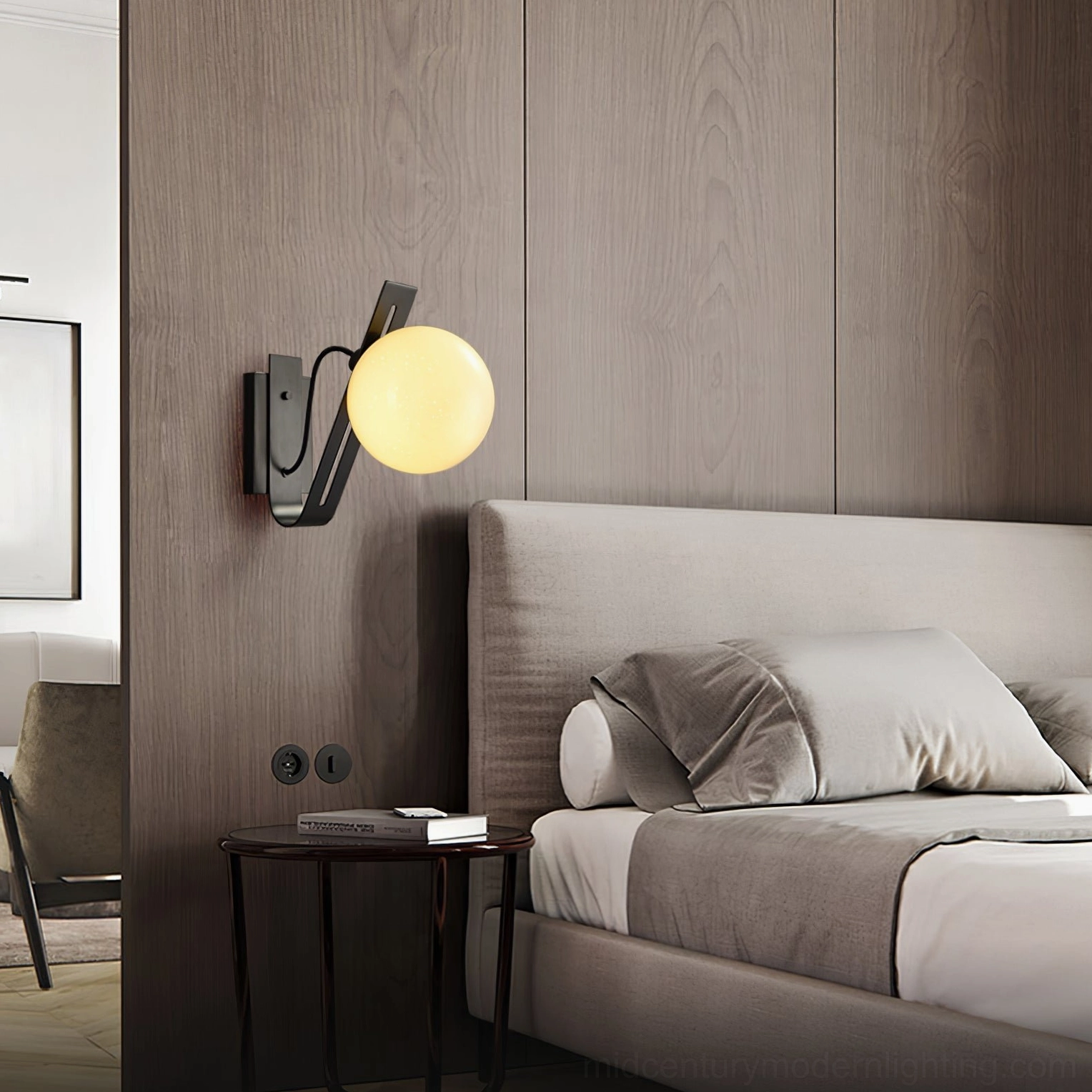 Illuminated black Arandela globe wall lamp casting warm glow in mid-century modern bedroom