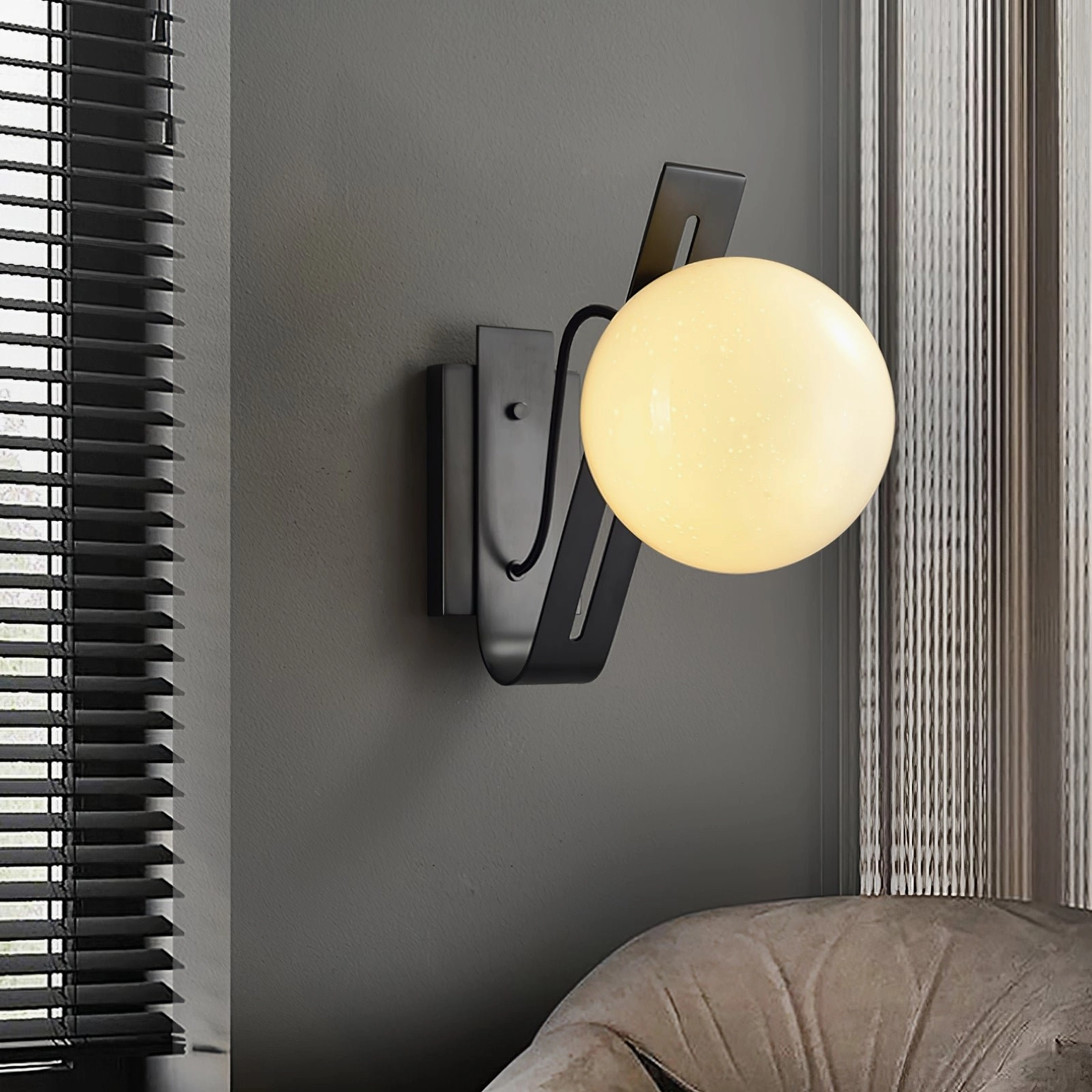 Two Arandela wall sconces in burnished brass flanking modern floating shelf arrangement
