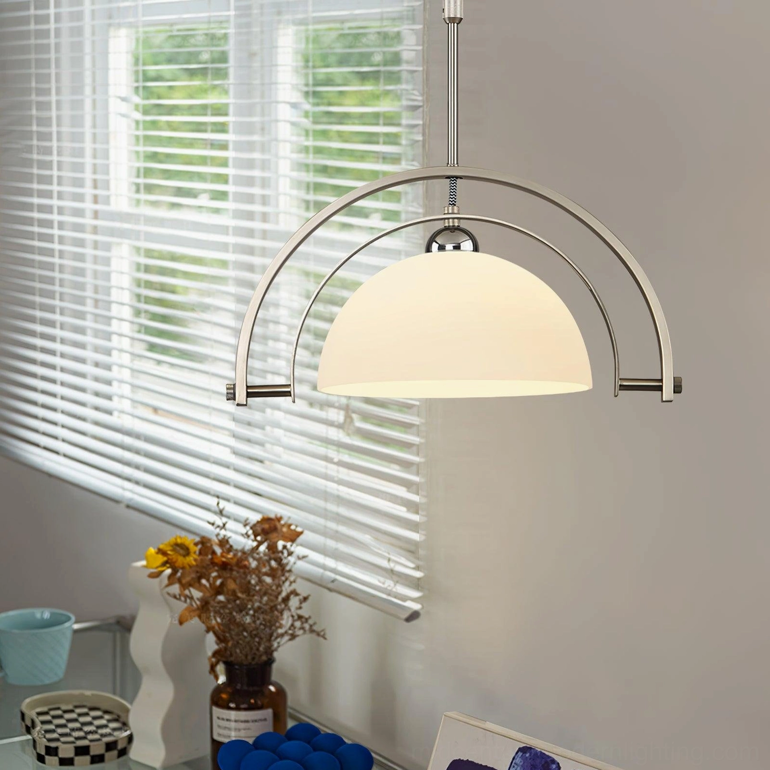 Illuminated arc pendant light in sunlit kitchen counter space with dried flower decorative elements