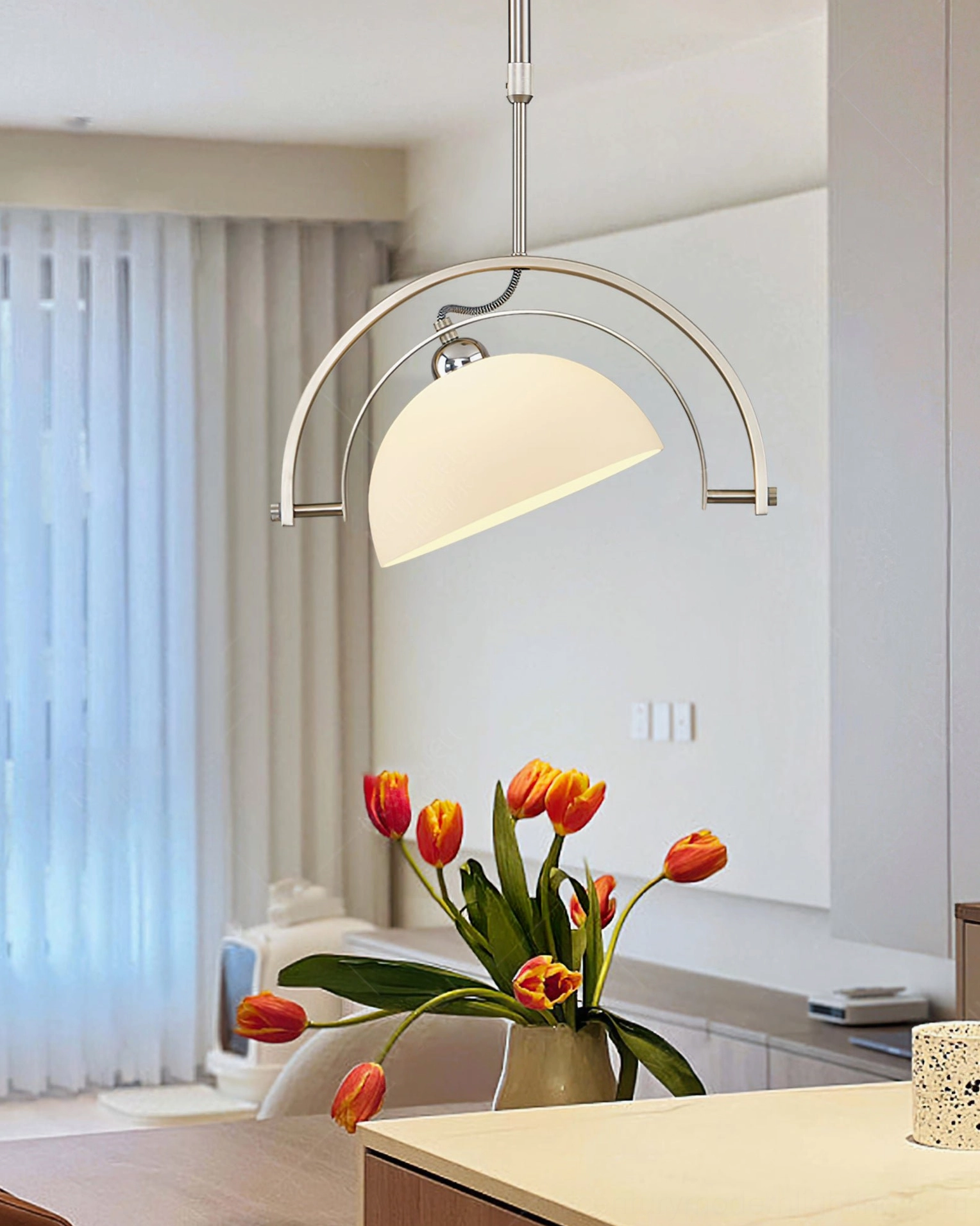 Mid-century arc pendant light installed in modern minimalist kitchen dining zone with tulip flowers and contemporary decor