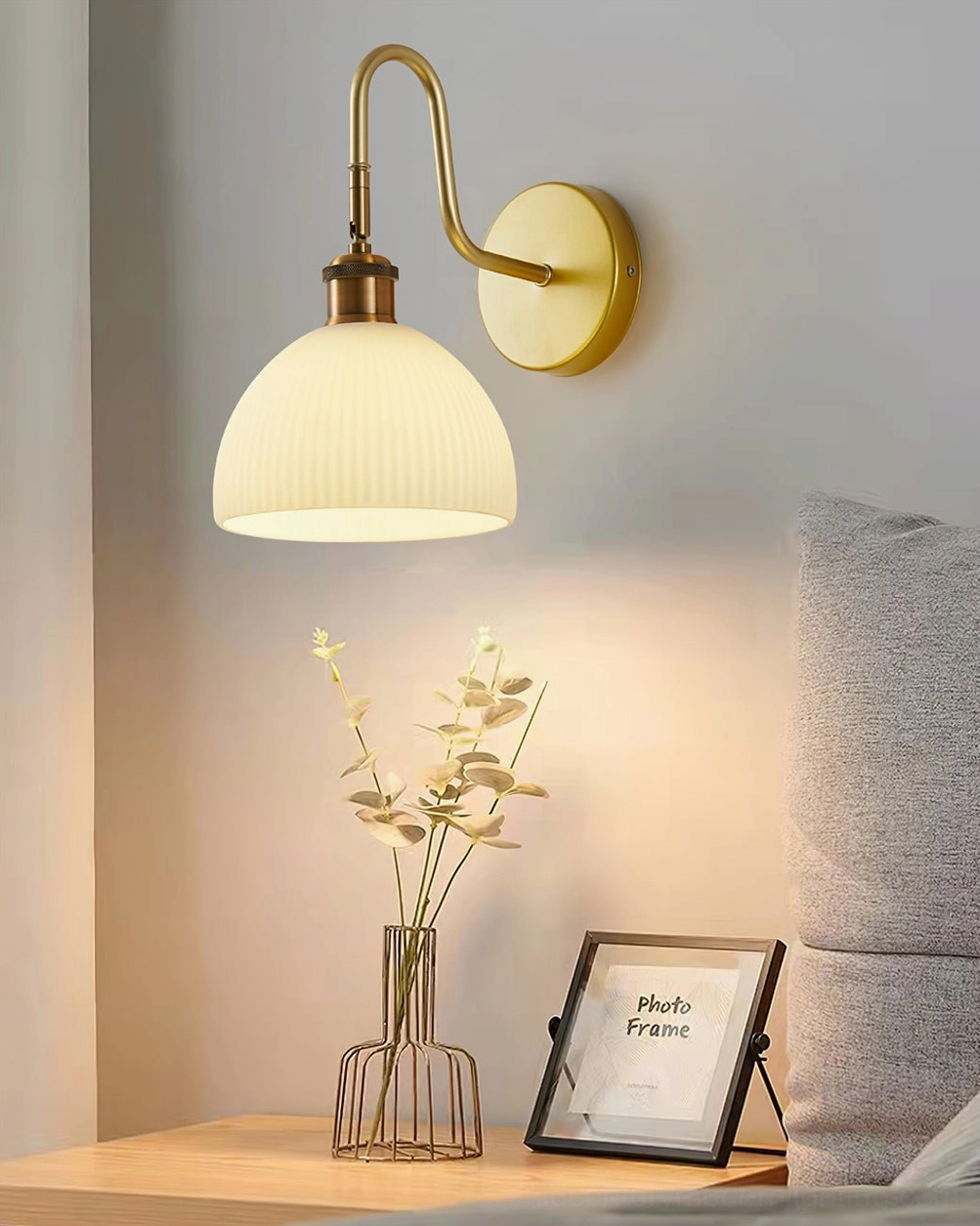 Arren bedside wall sconce emitting warm ambient light above bedroom nightstand, mid-century modern lighting