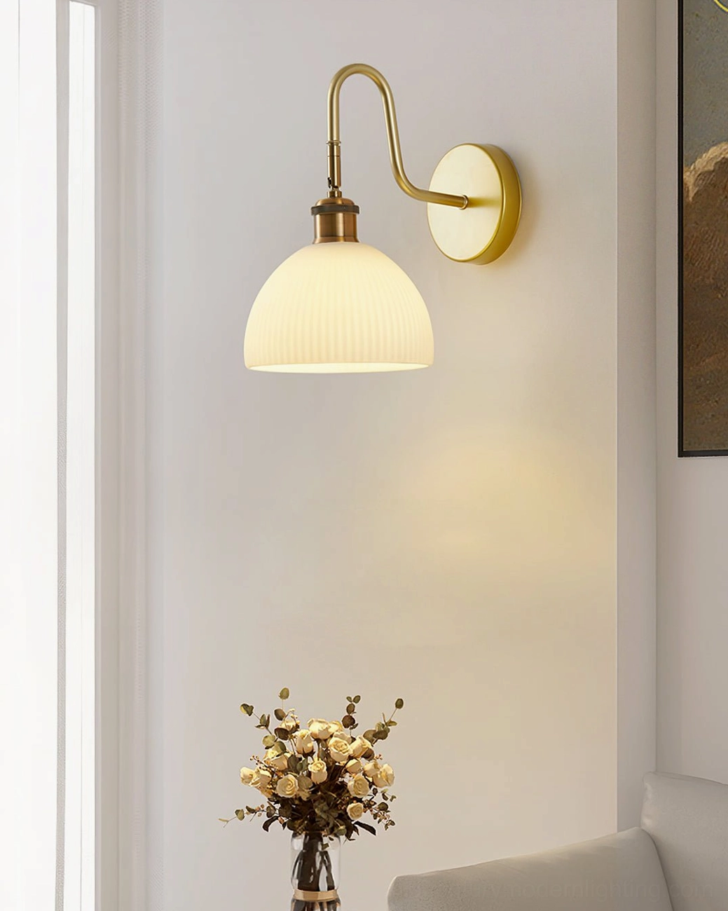 Minimalist Arren wall sconce with brass gold base and neutral ribbed dome shade in modern living room