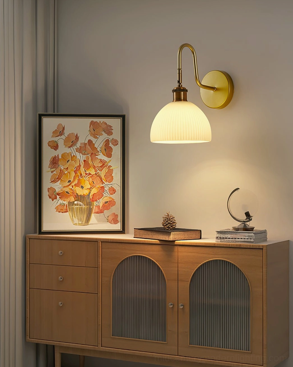 Unlit Arren wall lamp with smooth brass arm and ribbed lampshade, mounted in living room with wooden cabinet