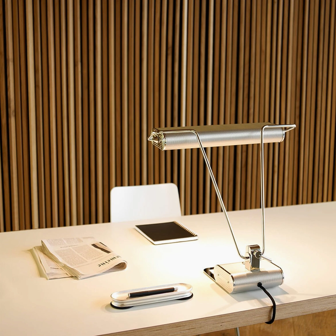 Art Deco 34 ribbed chrome table lamp on wooden workspace desk with office stationery and papers