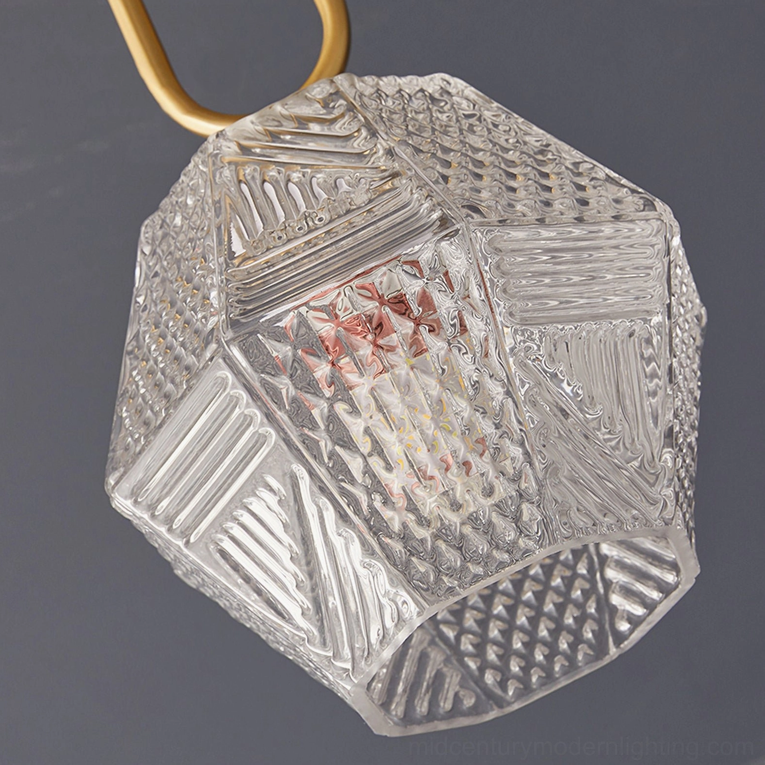 Brass Art Deco pendant light casting geometric shadows with faceted glass