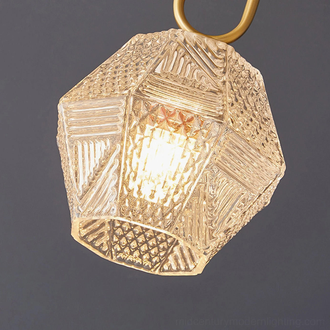 Brass Art Deco pendant light with faceted glass shade overhead view illuminated