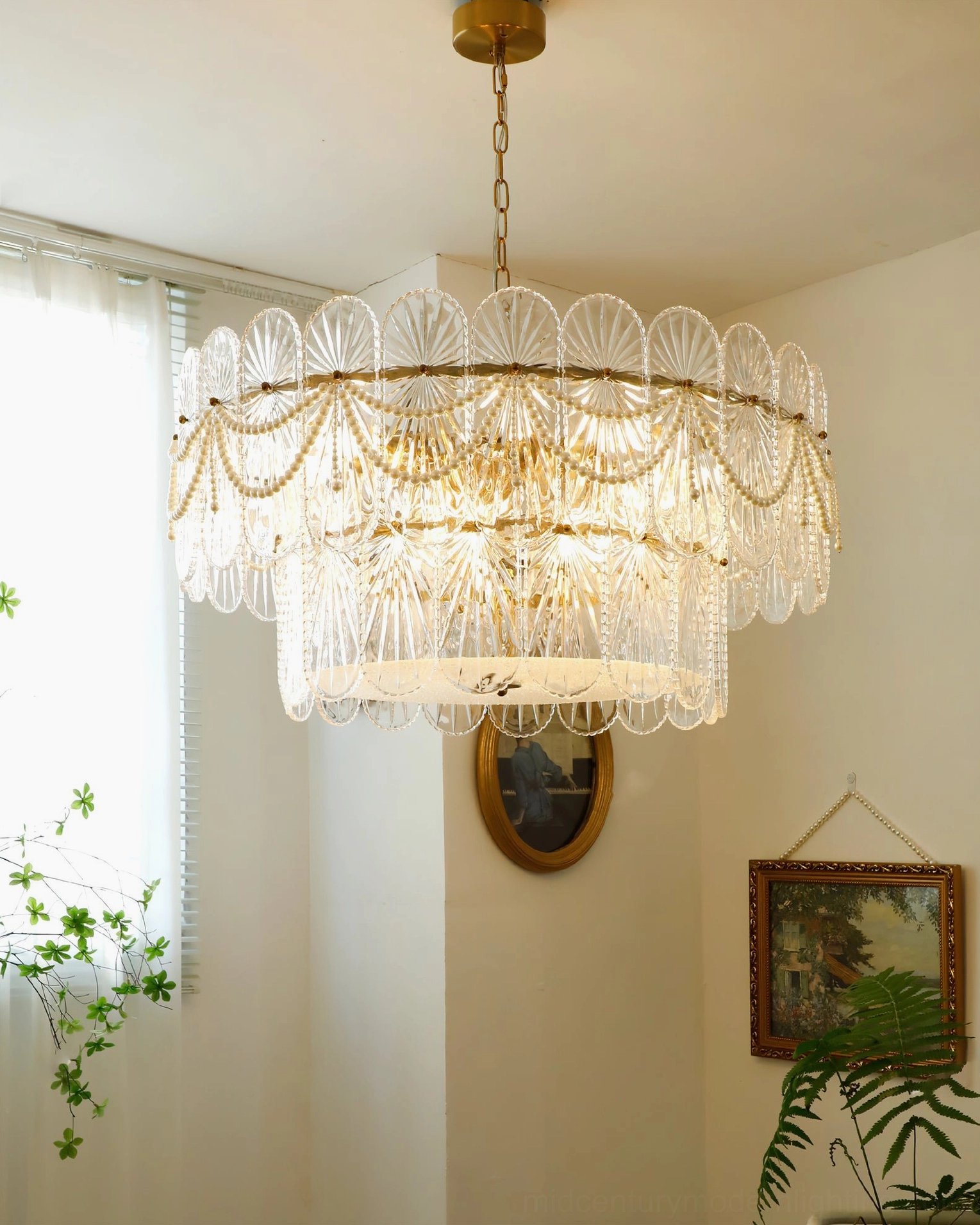 Art Deco style glass chandelier with scalloped detailing and pearl beaded accents hanging from ceiling