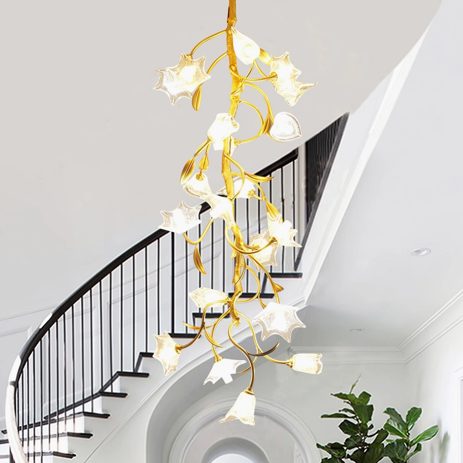 Artisan glass flower chandelier above black metal spiral staircase with high ceiling and warm recessed lighting