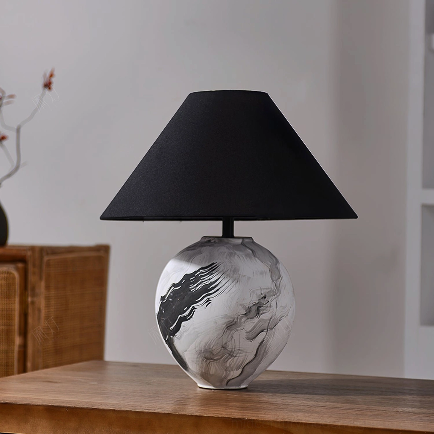 Contemporary ceramic table lamp with black linen shade showing artistic base pattern on wooden side table