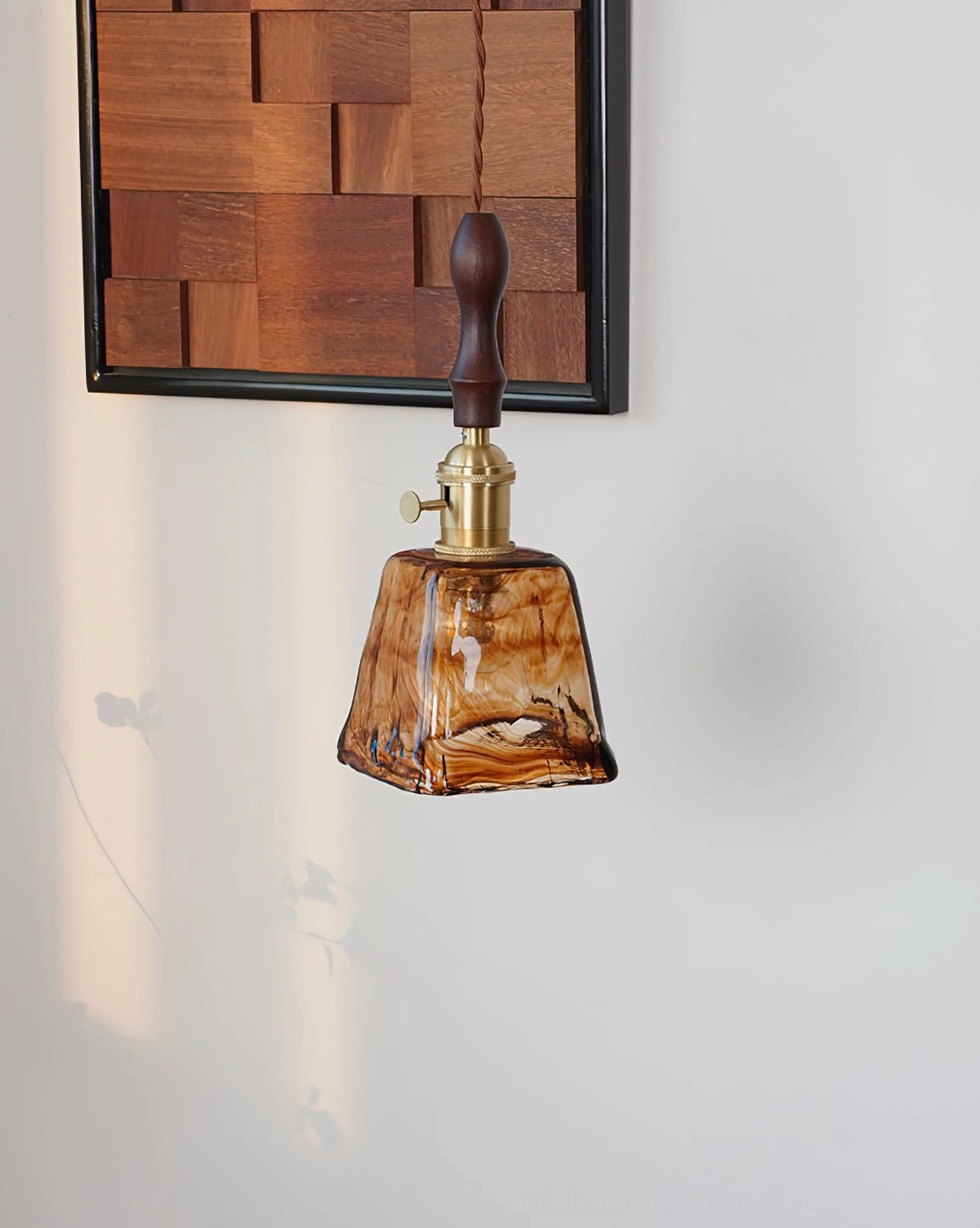 Artistic glass pendant lamp with organic form creating diffused amber glow in residential interior
