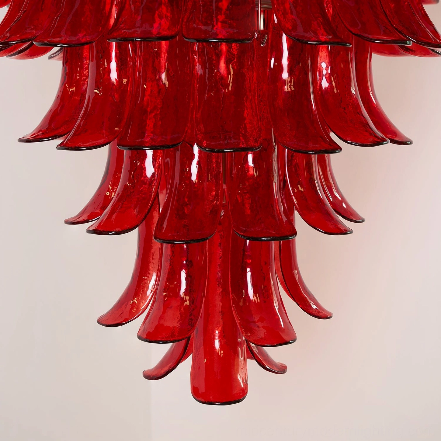 Artistic close-up of Murano hand-blown glass chandelier showing intricate red petal layers and translucent glass light diffusion qualities