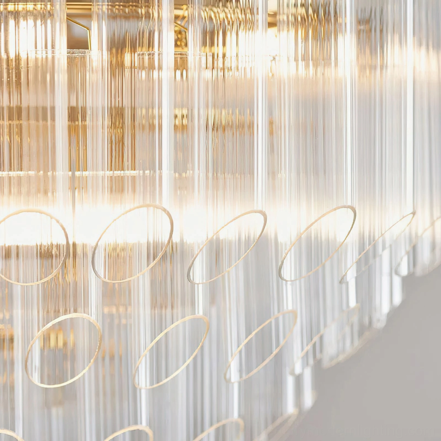 Astoria Waterfall Glass Chandelier detail - close-up of fluted clear glass tubes with circular cutouts and warm backlighting