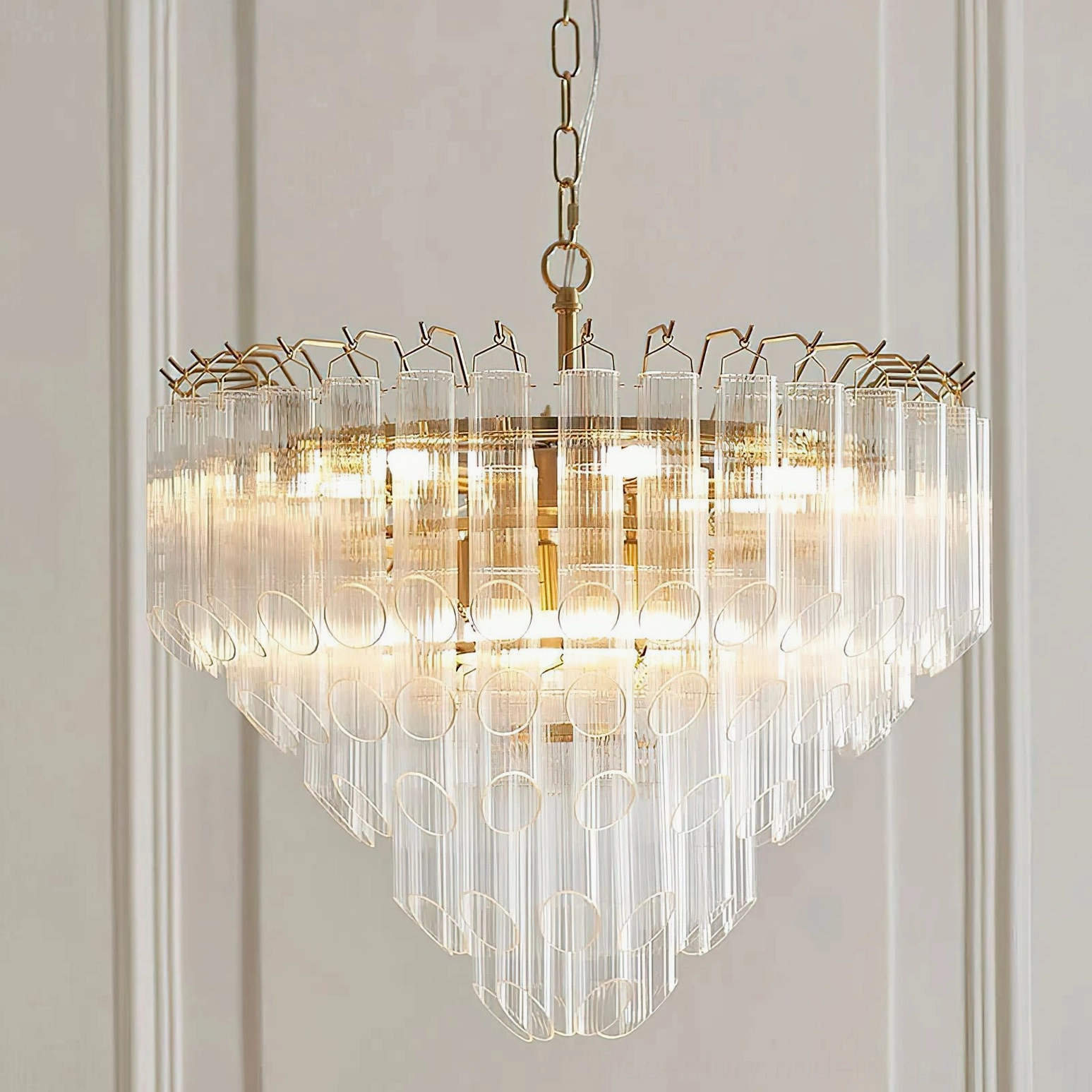 Astoria Waterfall Glass Chandelier hanging display - layered clear glass shades with warm brass suspension on interior wall