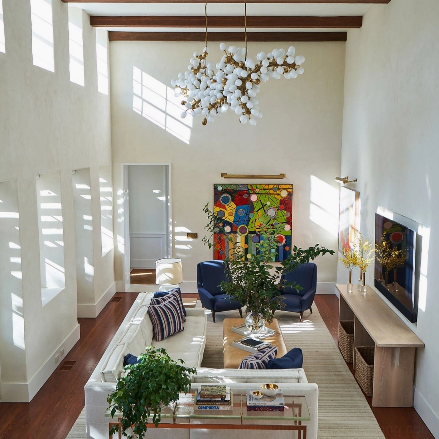 Asymmetrical bubble chandelier with frosted white glass orbs in double-height modern living room with high ceilings