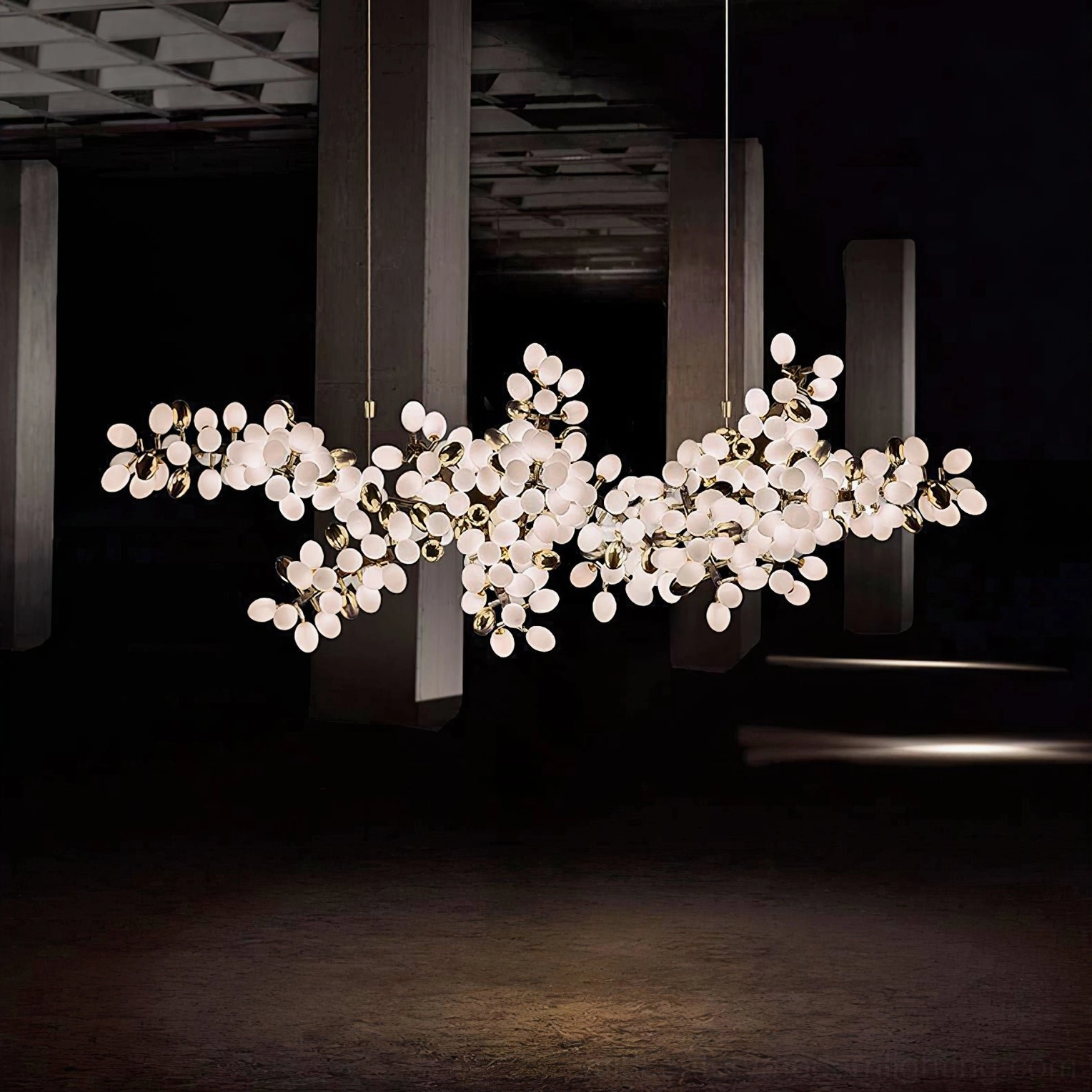 Asymmetrical grape vine chandelier casting soft frosted light in moody dark luxury living space