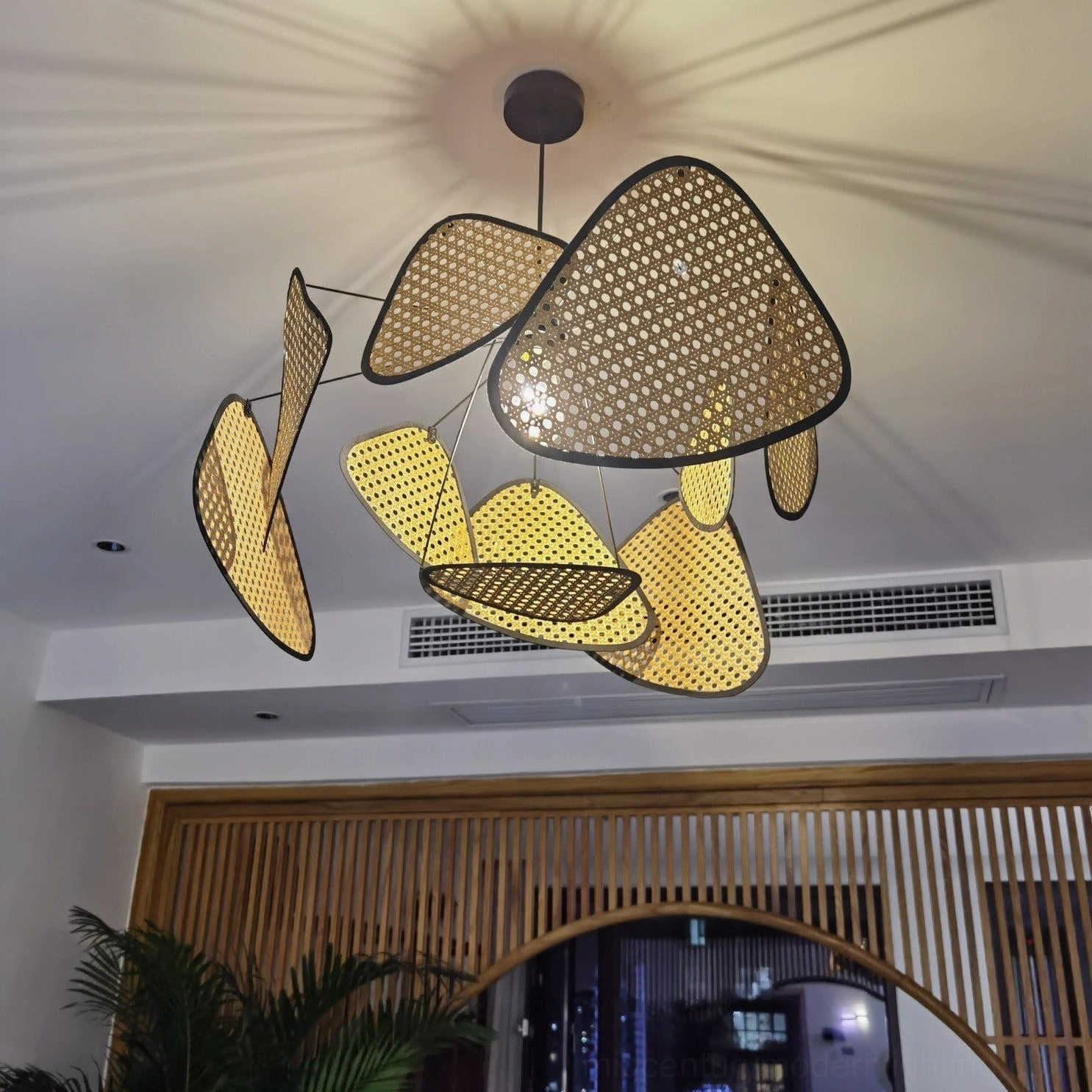 Scattered organic perforated rattan pendant shades with warm neutral color palette, modern home interior lighting design